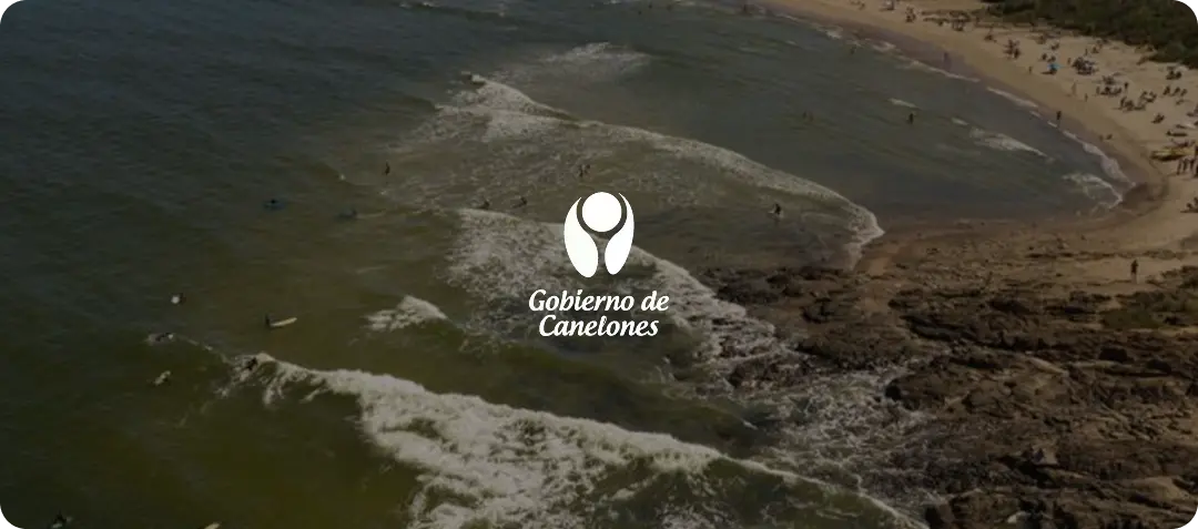 Gobierno de Canelones logo over aerial view of busy beach